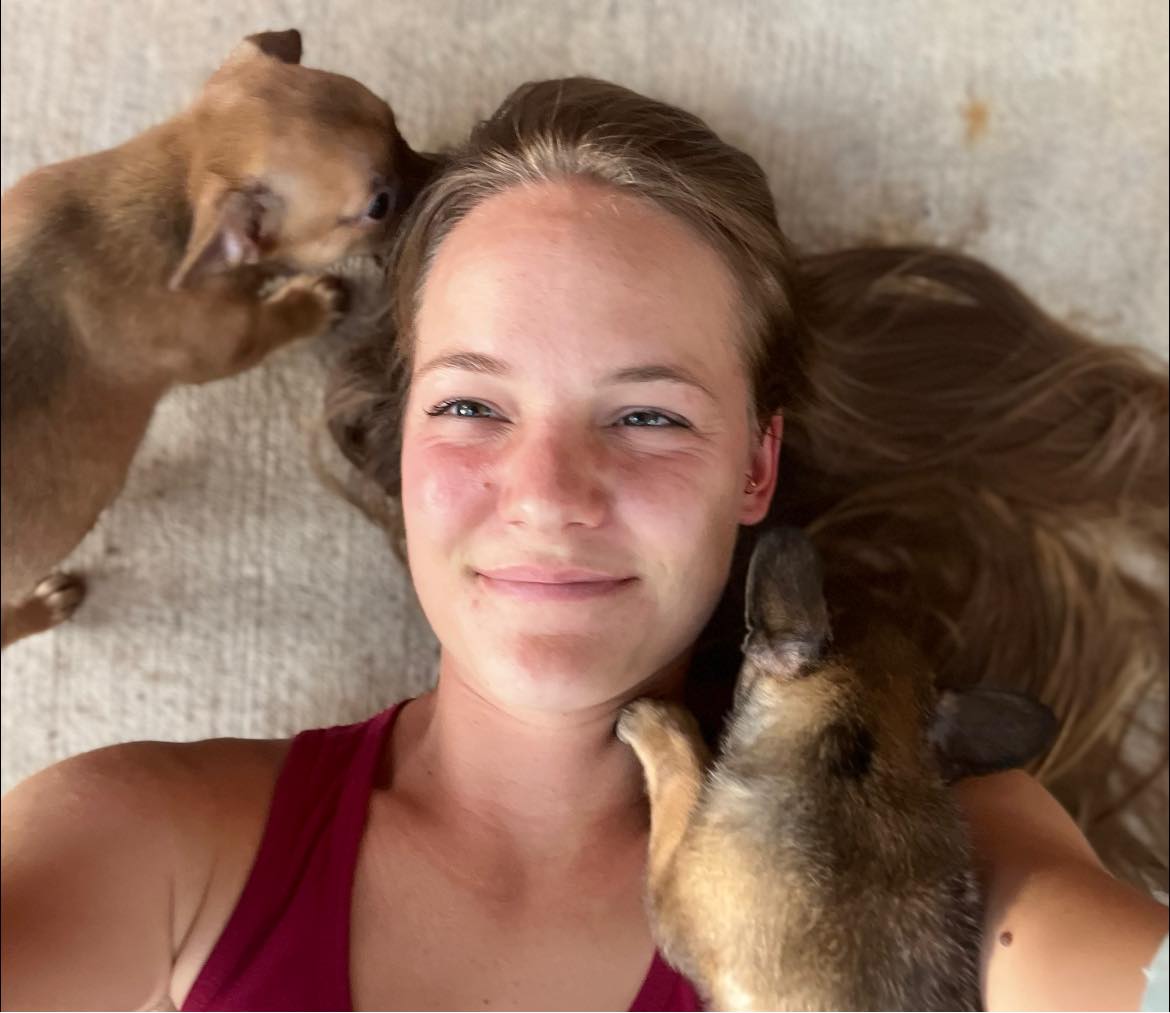 happy woman getting selfie with puppies