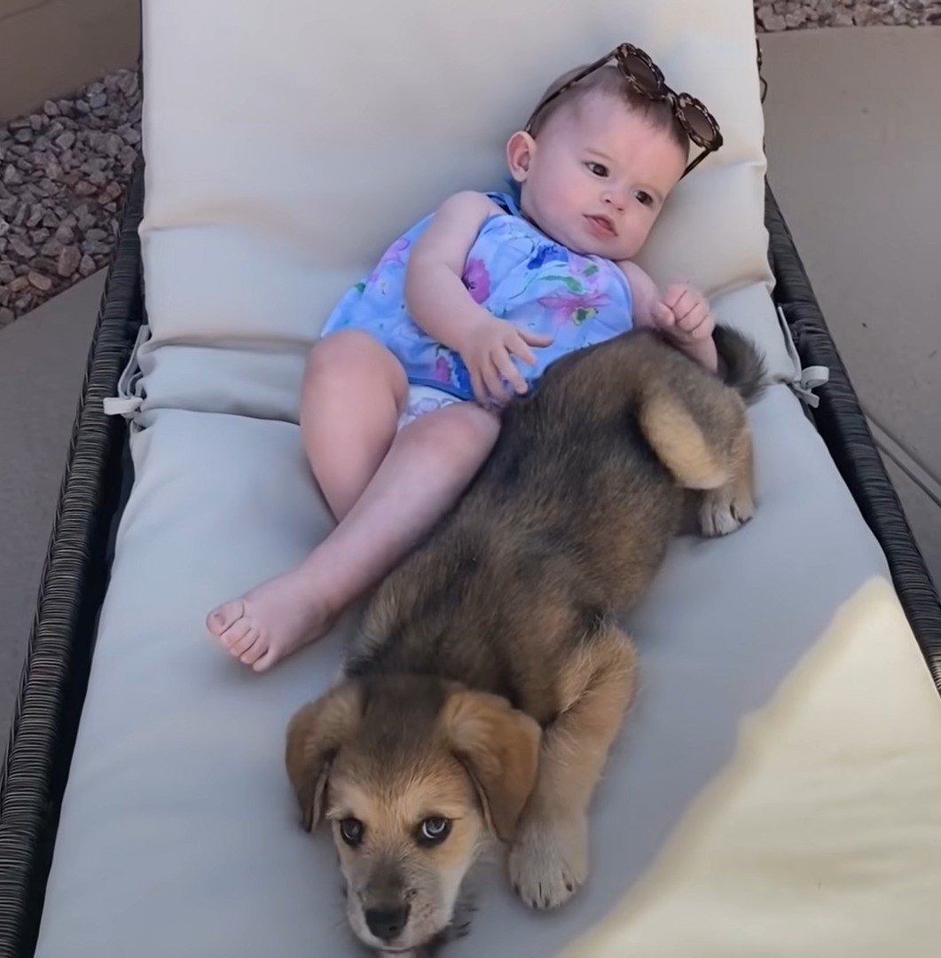 baby relaxing with puppy