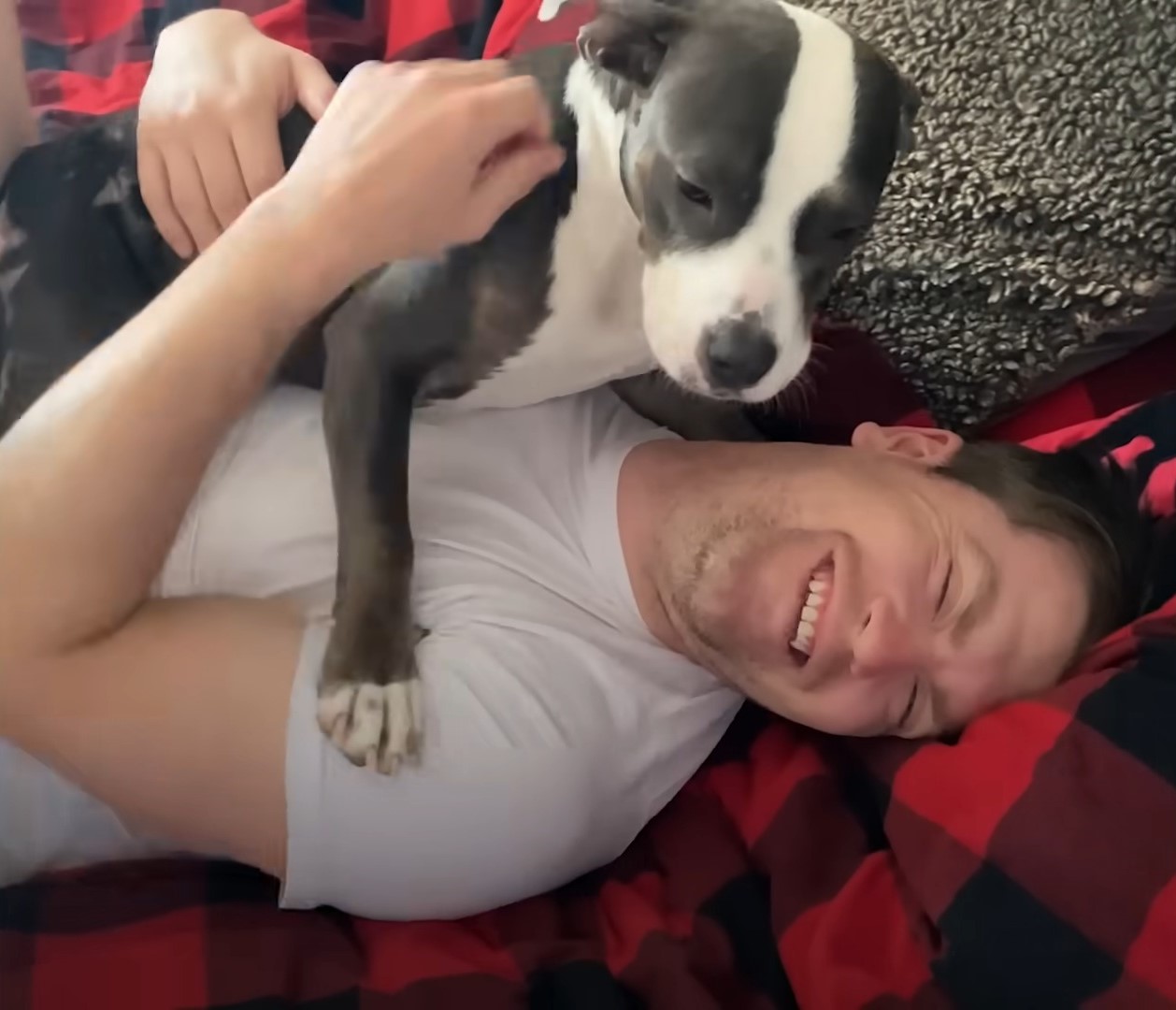 man and dog cuddling