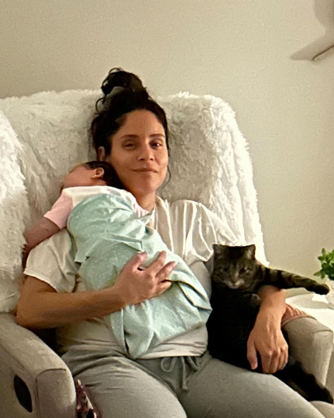 woman holding a baby and a cat