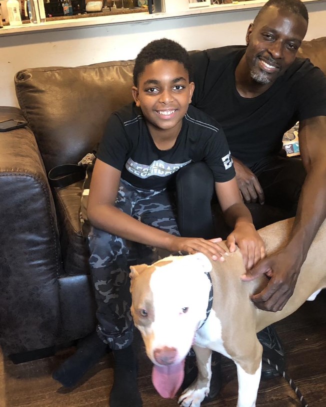 portrait of a father and son with a new dog in the home