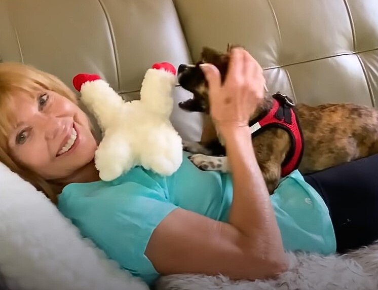 happy woman with dog and a toy