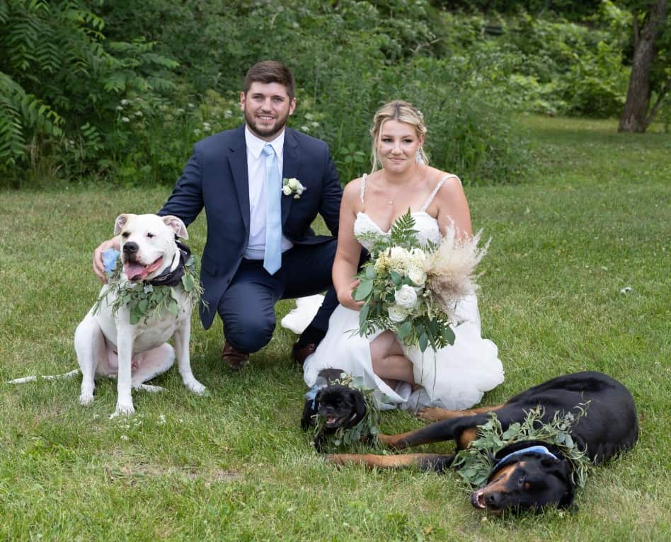 a man and a woman at a wedding with their dogs