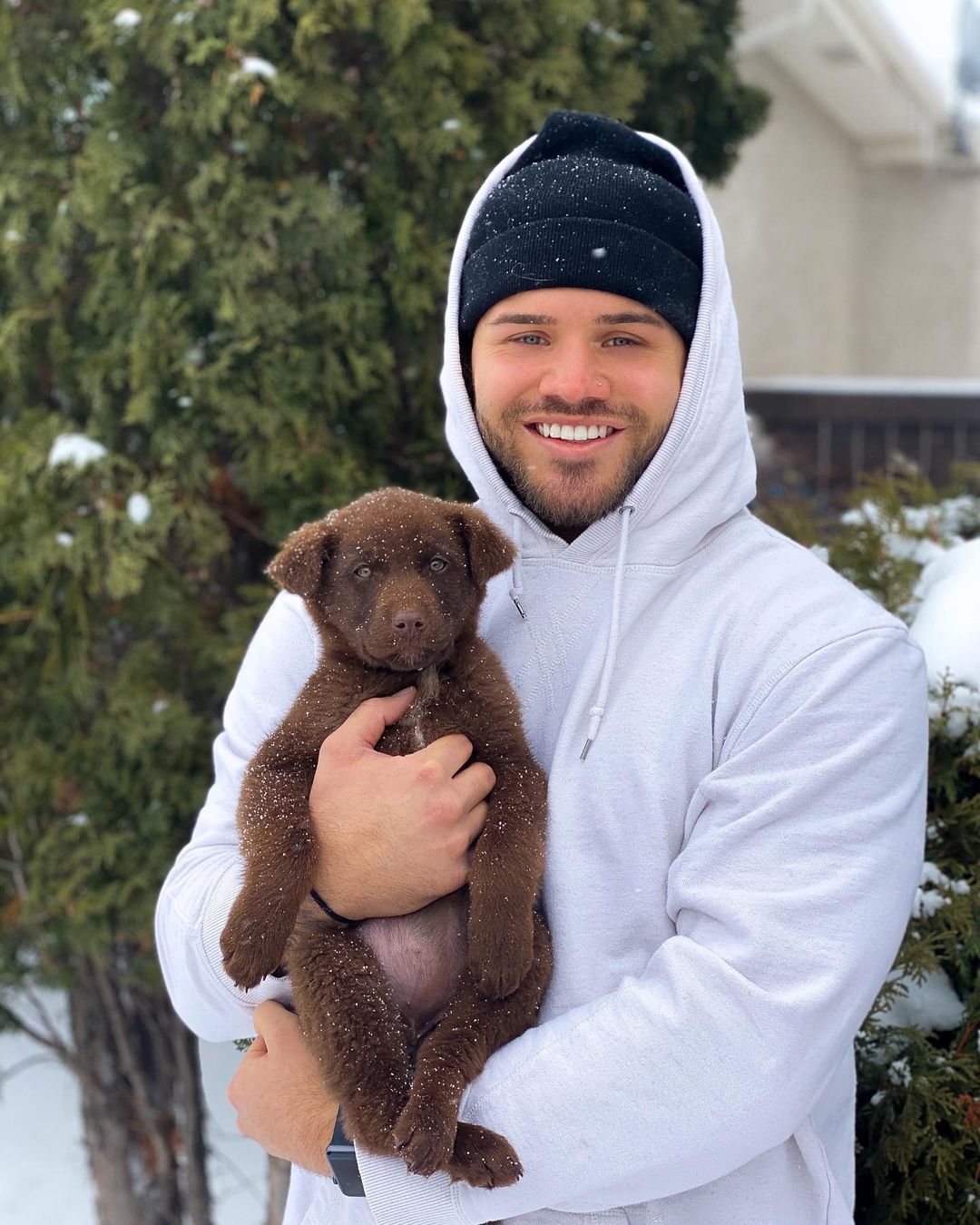 owner holding his puppy while snows