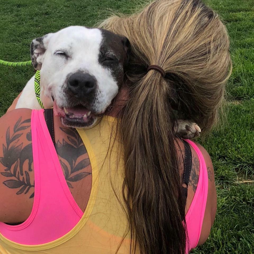 tatooed girl and a dog hugging