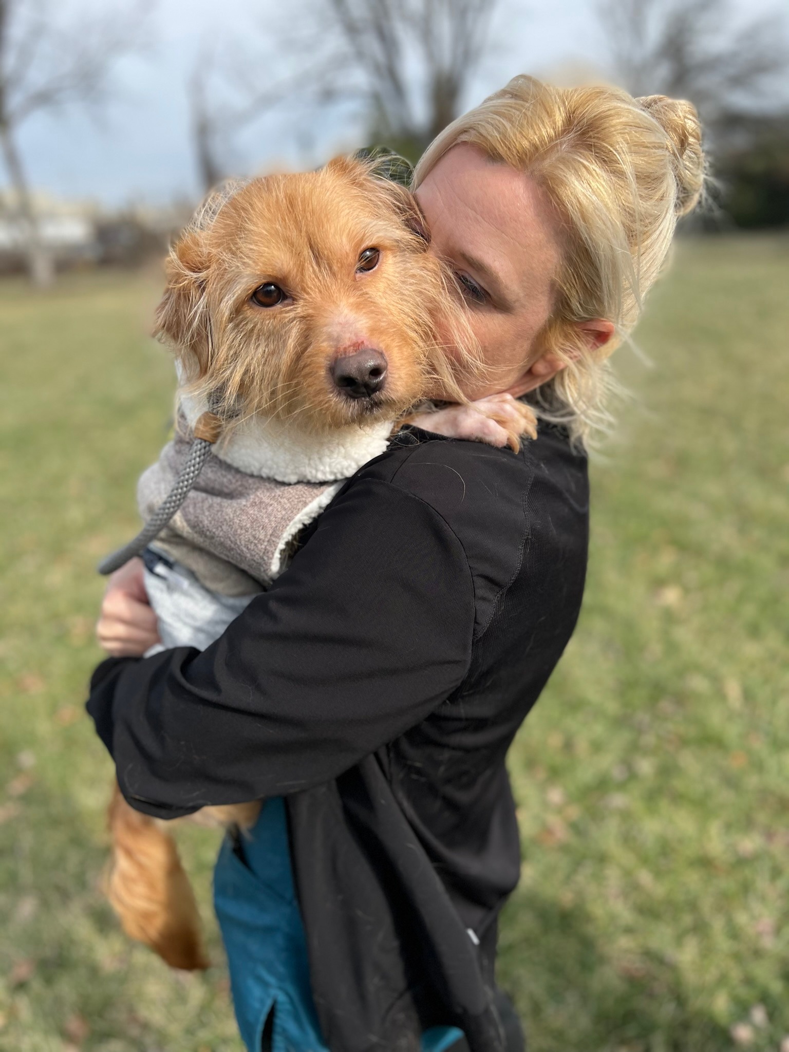 blonde woman holding a adopted dog