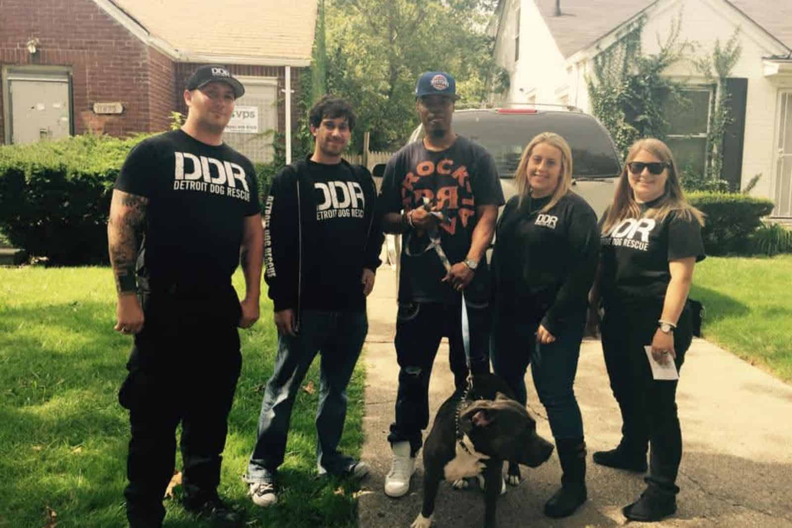 DDR staff with pitbull mix dog standing on driveway