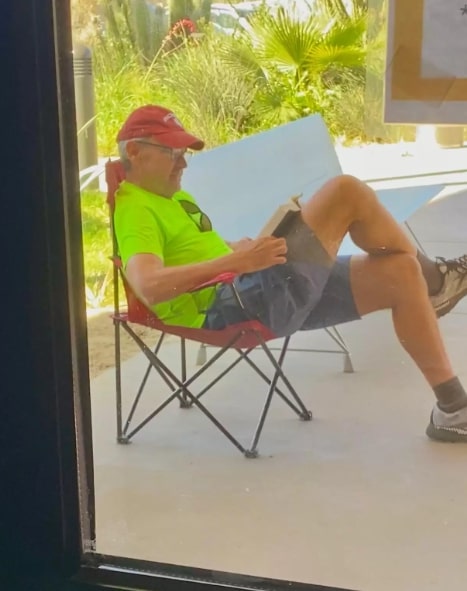 a man sits on a chair and reads a book