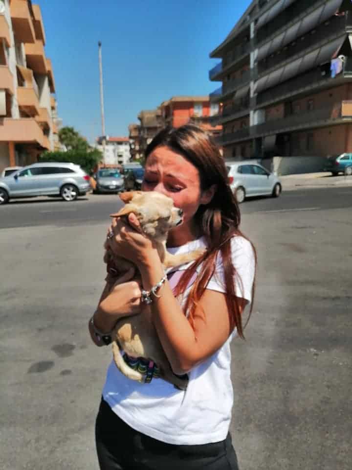 woman kissing her dog and crying