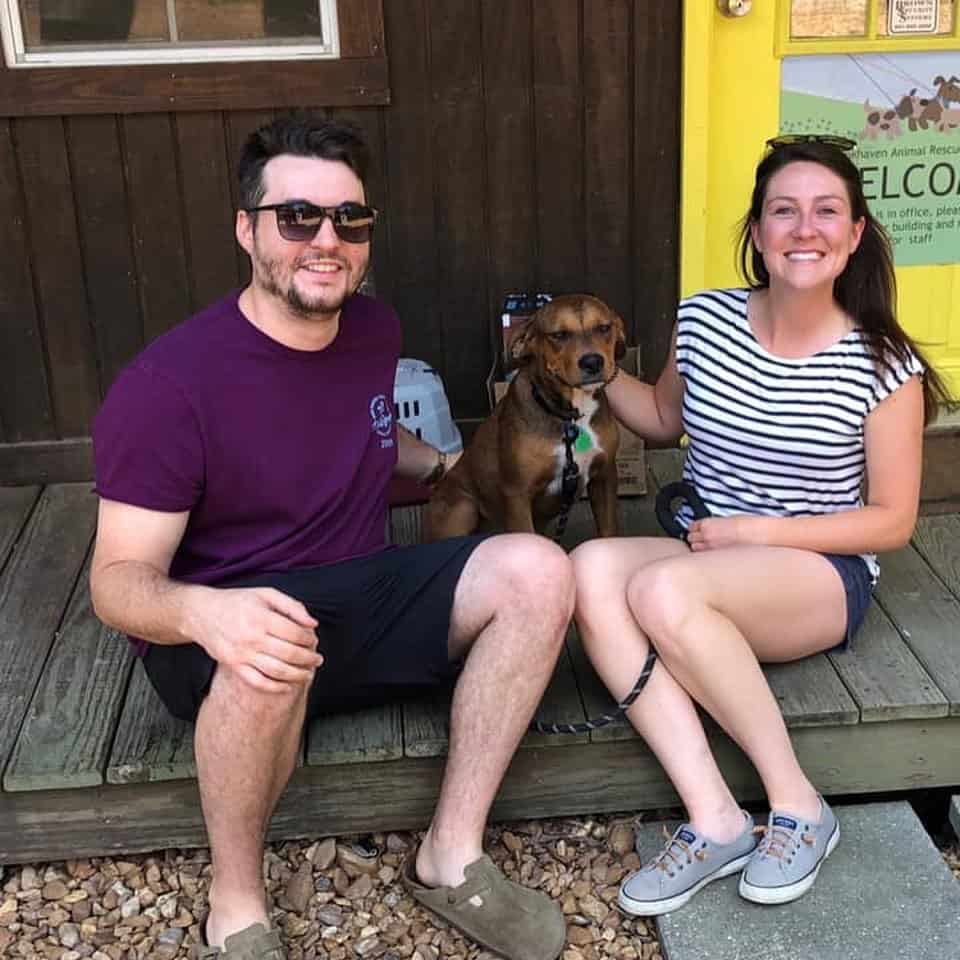 happy couple posing with dog